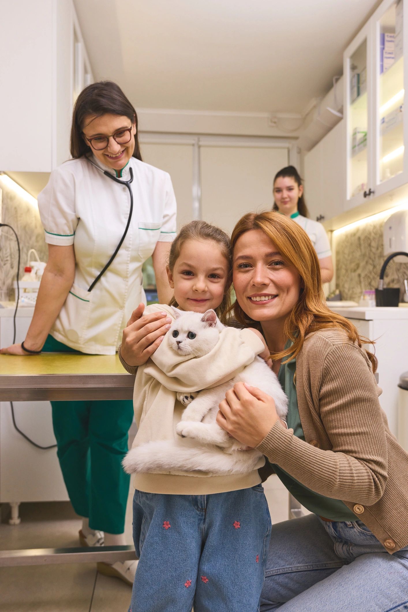 Friendly pet care professionals with a family and cat